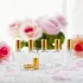 Clear glass refillable perfume atomizers with shiny gold caps and sprayers, elegant floral detail. - Gold