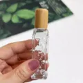Vue détaillée d'un flacon roll-on en verre avec motif losange et bouchon en bambou naturel. - Flacon texturé de 12 ml / Transparent