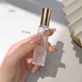 Detailed view of a 12ml diamond patterned glass perfume bottle with gold cap and size marks. - Gold