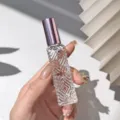 Diamond glass perfume bottle detail view with purple cap and clear textured spray design. - Rose Pink
