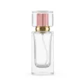Close-up detail view of the clear glass perfume bottle with square transparent cap and gold pump. - Pink