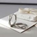 Primer plano de pendientes de aro infinitos de plata con brillantes circonitas - Oro blanco