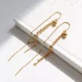 Elegantes pendientes largos de borla de plata S925 con cuentas doradas en fondo blanco. - Plata 925 / Dorado