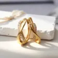 Elegantes pendientes de aro dorados con diseño de infinito y circonitas brillantes. - Dorado