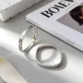 Elegantes pendientes de aro de plata S925 con un patrón texturizado de escamas de pez. - Plata 925 / Oro Blanco (K931)