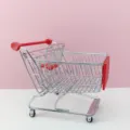 Détail de mini caddie en métal, poignée rouge et panier en fil pour décoration de table. - Rouge