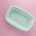 Gros plan détaillé du panier de rangement en plastique tressé, couleur vert menthe doux. - Vert clair