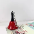 Vista detallada del llavero de campana rojo y negro con cadena y anillo metálicos. - Llaveros de cascabel rojo