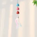 Primer plano detallado de campana colorida con mini campanas y plumas suaves para decoración. - Triple Capa