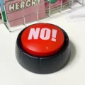 Vista de cerca del divertido botón zumbador de juego rojo y negro, ideal para juguetes interactivos. - NO / Rojo