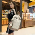 Großer weiß-beiger Schulrucksack mit einem niedlichen Pinguin-Plüschanhänger - S / Mit Anhänger / Khaki