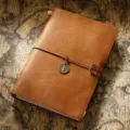 Carnet de voyage vintage en cuir véritable avec pendentif métallique et lanière. - Modèle A5 / Cuir Crazy Horse marron clair
