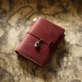 Carnet de voyage en cuir vintage journal intime avec pendentif en metal et elastique. - Format passeport / Rouge Vin Crazy Horse