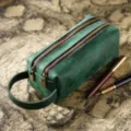 Green leather double-layer pencil case with handle, vintage map background, and pens. - Crazy Horse Dark Green