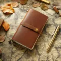 Carnet de voyage en cuir marron vintage avec sangle et stylo en laiton pour ecrire. - Taille portable / Marron