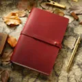 Vintage carnet de voyage en cuir rouge avec fermeture par lanière et porte-stylo élégant. - Modèle A5 / Bordeaux