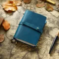 Carnet de notes vintage en cuir avec fermeture à lanière et papier pour la planification. - Format passeport / Teinte Bleutée