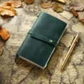 Carnet de voyage en cuir vert foncé vintage avec lanière et stylo en laiton sur fond de carte ancienne - Taille portable / Vert Foncé