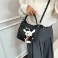 Elegante schwarze Beuteltasche aus Leder mit Krokodilprägung, Drehverschluss und Anhänger - Mit Anhänger / Schwarz