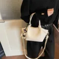 Elegante cremeweiße Commuter-Eimertasche mit süßem Hund Anhänger und Knotendetails - Mit Anhänger / Gebrochenes Weiß