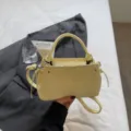 Elegant light yellow commuter bucket bag with a top handle and adjustable strap - Single Bag / Yellow