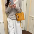 Soft yellow woven leather bucket bag for women with decorative wooden bead tassel - Pendant Style / Yellow