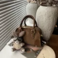 Elegant brown soft leather pillow bag with cute plush bunny charm for women's daily use - With Charm / Brown