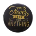 Round black tinplate badge with gold inspirational text IT'S Never LATE FOR ANYTHING - It's Never Too Late for Anything Inspirational Quote (MXZ095)