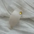 Eleganter cremeweißer ovaler Haarclip mit goldenem Hand Made Tag auf Stoffstruktur - Ellipse / Gelee-Weiß