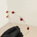 Elegant gold bridal headband featuring delicate red velvet roses and white faux pearls - Rose Wave Style