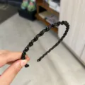 Close-up of wavy black crystal headband showing delicate faceted bead details - Black