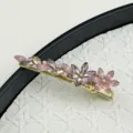 Close-up of sparkling crystal flower hair clip with pink and champagne stones. - Pink