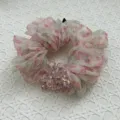 Detailed view of a pink floral organza scrunchie featuring faceted crystal bead accents - Pink Green