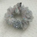 Detailed close-up of a floral organza scrunchie with faceted crystal bead cluster - Light Blue