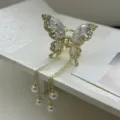 Elegant gold butterfly hair claw clip featuring sparkling rhinestones and pearl tassels. - Gold