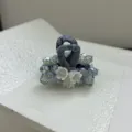 Macro view of an elegant hair claw clip with blue beads and white bellflower charms. - Light Blue Small
