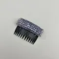 Detailed top view of a sparkling purple crystal hair side comb with black plastic teeth. - Purple
