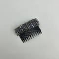 Detail view of iridescent purple and grey crystal beads on a black toothed hair comb - Grayish Purple