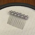 Détail d'un peigne à cheveux avec perles grises et cristaux sur fond tressé - Violet Nuage