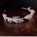 Elegant bridal crystal hair tiara with intricate leaf details shown on dark wood background - Rhinestone Hair Crown