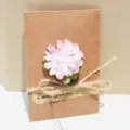 Vintage wenskaart van kraftpapier met roze droogbloem en decoratief jutetouw versiering - Roze Anjer / Kleine Envelop (s335)