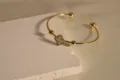 Vergoldetes Edelstahl Armband mit einem zarten Perlmutt Kleeblatt Motiv für Damen. - Weiß