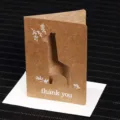 Minimalist kraft paper thank you card featuring a laser-cut giraffe and matching white envelope - Giraffe