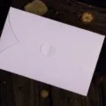 Een elegante ijs-witte parelmoeren envelop met een creatieve hartvormige sluiting - IJswit Parelmoer