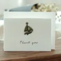 Elegante tarjeta de agradecimiento blanca con un dije de velero de bronce y sobre - Estilo Velero (305#)