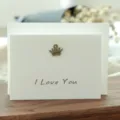 Tarjeta de felicitación blanca vintage con dije de corona de bronce e I Love You - Estilo Corona (305#)