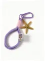 Close-up of a handmade purple and pink braided lanyard with gold starfish pendant and hook. - Purple