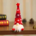 Nahaufnahme eines Weihnachtswichtels mit leuchtendem Bart und gestreifter Mütze Dekoration - Sitzende Haltung / Rot