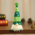 Detailaufnahme eines leuchtenden Weihnachtswichtels mit grün gestreifter Mütze - Sitzende Haltung / Grün