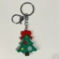 Detailansicht eines grünen Tannenbaum-Schlüsselanhängers mit roter Schleife und Ring. - Schleife Stern Schneeflocke Weihnachtsbaum Stil / Grün
